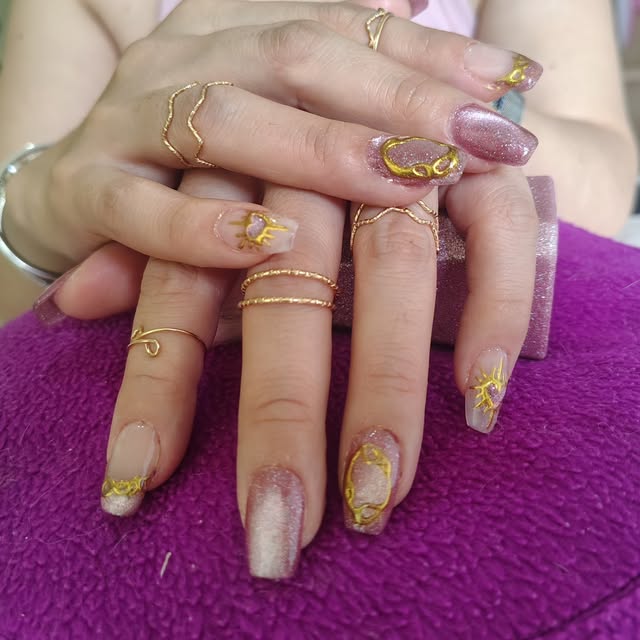 Uñas rosas y doradas con brillos y detalles modelados