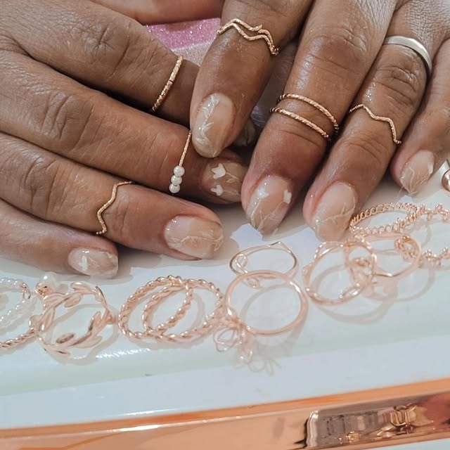 Manicura nude con perlas y joyería dorada
