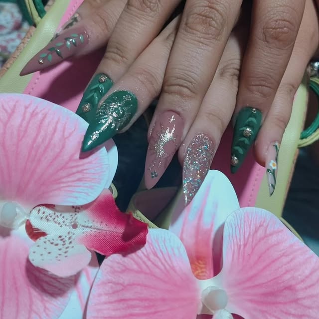 Uñas verde esmeralda y rosas con brillo entre flores